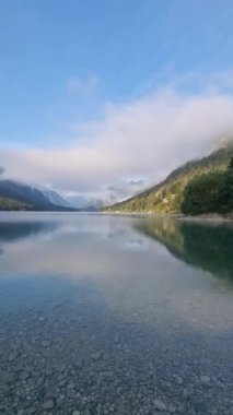 Şafak vakti, berrak suların yemyeşil ve çevresindeki tepeleri yansıttığı sakin bir dağ gölünün güzelliğini yaşayın. Huzurlu bir düşünce anı yaşayın. Plansee Avusturya