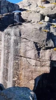 Nefes kesen bir şelale kayalık kayalıklardan aşağı yuvarlanıyor. Etrafı göz kamaştırıcı dağ manzarasıyla çevrili. Kjeragbolten uçurumu Norveç 'teki Lysefjord üzerinde nefes kesici manzaralar sunuyor,