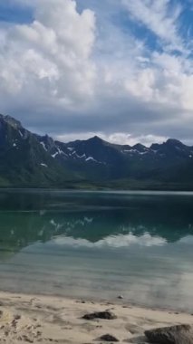 Şafak vakti Norveç 'in nefes kesici zirvelerini yansıtan sakin sulara bakın. Doğa, güzellik ve barış senfonisi içinde uyanıyor. Herkesi Lofoten' daki sabah güneşini kucaklamaya çağırıyor.