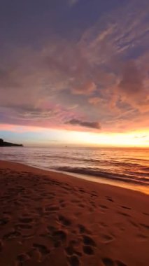 Alacakaranlık 'ın büyüleyici güzelliğine tanık olun. Titreyen gökyüzü, sakin kumsalın üzerinde bir renk tuvaline dönüşüyor. Nazik dalgalar altın kumları okşuyor..