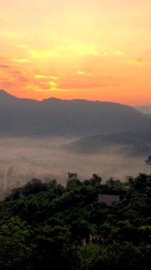 Altın ışınlar sislerle kaplı vadileri aydınlatırken güneşin doğuşunun ilham verici güzelliğine tanık olun. Huzurlu atmosfer dalgalı tepeleri sarıyor, Phu Langka Tayland