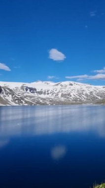 Norveç 'in yaz aylarındaki fiyortlarının nefes kesici güzelliğini tecrübe edin. Dalgalı mavi suların yükselen karlı tepeleri yansıttığı yerde..