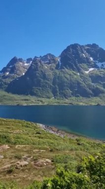 Aşağıdaki dingin göle yansıyan Norveç engebeli dağlarının nefes kesici güzelliğine tanık olun. Canlı yeşilliğin ve açık mavi gökyüzünün tadını çıkarın. Bu mükemmel doğa cennetinde..