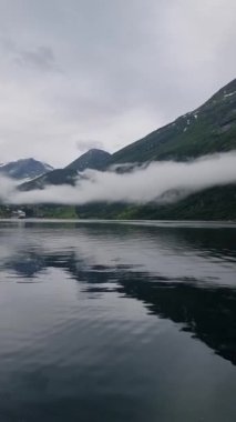 Sis sakin sularda dans ederken Norveç fiyortlarının dingin güzelliğini keşfedin. Görkemli dağlarla çevrili ve doğanın kalbindeki yemyeşil havayı içine çek..