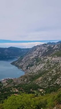Karadağ Kotor Körfezi 'nin nefes kesici güzelliğini keşfedin, sakin sular çarpıcı dağları yansıtırken. Doğada huzur içinde, görkemli zirveler ve yemyeşil ortamda..