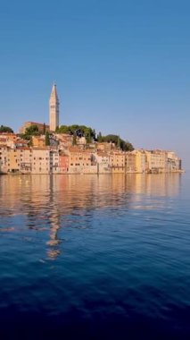 Rovinj 'in nefes kesici güzelliğine tanık olun. Rıhtım boyunca uzanan renkli binaların üzerinde altın güneş yükseliyor. Hırvatistan' da huzurlu bir sabah sabahında sakin Adriyatik Denizi 'nde yansımalar oluşuyor.