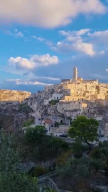 Matera 'nın büyüleyici güzelliğini keşfedin güneş tarihi mimarisinin üzerinde batarken. Tepelerde yuva yapmış bu antik şehrin cazibesini, büyüleyici manzaraları ve dingin atmosferini tecrübe edin..
