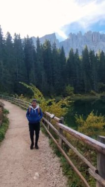 İtalya 'daki Carezza Gölü ya da Karersee Dolomitleri' nin yüksek dağları ve canlı sonbahar yapraklarıyla çevrili temiz bir göl kenarındaki orman yolu boyunca sakin bir yürüyüş deneyiniz..