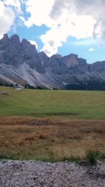 Dolomitlerin büyüleyici güzelliğine tanık olun. Altın güneş ışığı yemyeşil çayırlar üzerine dramatik gölgeler düşürüyor. Bu sakin manzarada doğa paleti tam olarak sergileniyor..
