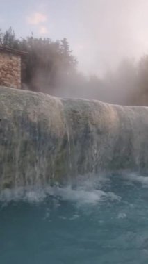 Su kayalık bir çıkıntının üzerinde zarifçe yuvarlanır ve etrafındaki ormanın sakin atmosferiyle harmanlanan yatıştırıcı bir ses yaratır. Saturnia, Toskana 'nın termal banyoları