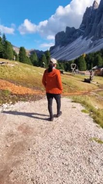 Bir insan Dolomitler 'de sakin bir şekilde dolaşır, büyüleyici dağlık araziler ve parlak mavi gökyüzü ile çevrili, doğanın sükunetiyle ıslanmış..