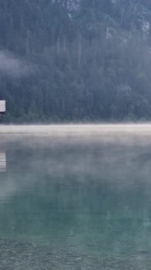 Sabahın erken saatlerinde sislerin durgun bir gölden yavaşça yükseldiğini, yemyeşil ormanların arasına yerleşmiş büyüleyici bir ahşap kulübeyi sardığını ve bir barış ortamı yarattığını hissedin. Plansee Avusturya