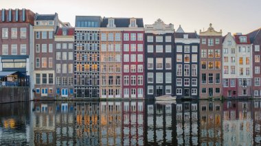 Güneş Amsterdam 'da batarken, büyüleyici kanallar, sonbahar renkleriyle süslenmiş tarihi binaların çarpıcı mimarisini yansıtıyor ve sakin ve resimli bir atmosfer yaratıyor..