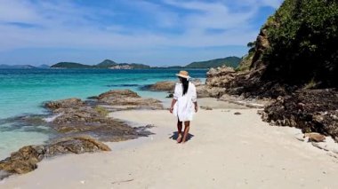 Bir kadın Samae San Adası 'nın kumlu kıyılarında huzurlu bir gezintinin tadını çıkarıyor. Berrak suları ve çarpıcı manzarasıyla, Asyalı bir kadın Tayland 'daki tropik bir adanın sahilinde yürüyor.