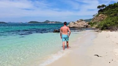 Samae San Adası 'nın el değmemiş sahillerinde gezinen bir adam turkuaz suları ve çarpıcı manzaraları gözler önüne seriyor. Tayland 'ın saklı mücevherinin canlı doğal güzelliğini tecrübe et..