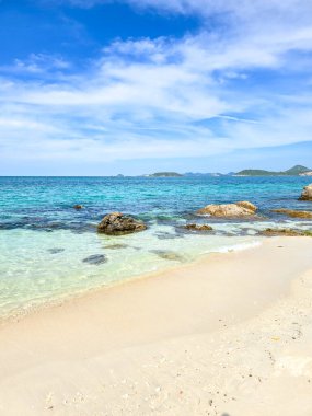 Berrak turkuaz sular Samae San Island Tayland 'ın kumlu sahillerine yavaşça yaklaşır. Parlak mavi gökyüzünün altındaki uzak adalar tarafından çerçevelenmiştir. Bu sakin nokta rahatlama ve keşfe davet ediyor..