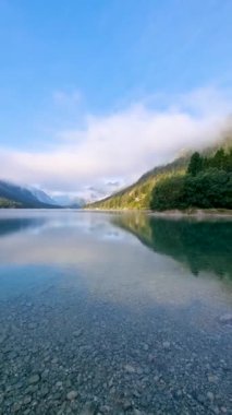 Plansee Avusturya, sakin sular görkemli dağları yansıtıyor kabarık bulutlar tembelce sürüklenirken. Huzurlu göl manzarası yansıma anlarını davet eder ve doğanın güzelliğini takdir eder..