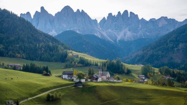 Canlı çayırlarda yuva yapmış büyüleyici köyler, Dolomitlerin çarpıcı zirveleri tarafından çerçevelenmiş alacakaranlığın yumuşak renklerinde güneşleniyorlar. Santa Maddalena Val di Funes İtalya