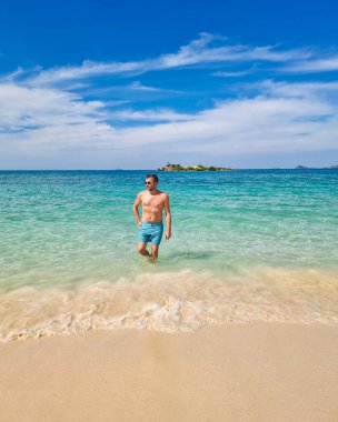 Samae San Island Tayland 'ın sığ turkuaz sularında hafif dalgalar ve yumuşak kumlarla çevrili bir gezgin duruyor. Güneş ışığı sahili yıkıyor, mükemmel bir tropikal cennet yaratıyor..