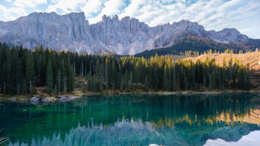 Dağlık bir gölün sakin suları, verimli kozalaklı ormanlarla çevrili yüksek Dolomite tepelerini yansıtır. İtalya 'da sakin bir an, Carezza Gölü veya Karersee Dolomitleri.