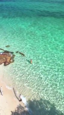 Tayland 'daki Koh Munnork Adası' nın sersemletici temiz suları. Unutulmaz manzarayla çevrili huzurlu bir yüzüşün tadını çıkarırken doğanın güzelliğinin tadını çıkar. Mavi okyanusta bir çift kadın ve erkek