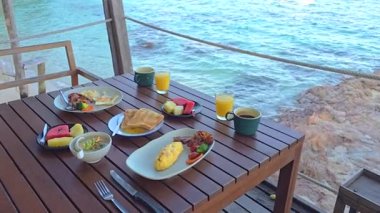 Taze tropikal meyveler, bir omlet ve yerel spesiyalitelerin yer aldığı lezzetli bir kahvaltı sofrasının tadını çıkarın. Hepsi de Tayland 'ın Rayong kentindeki güzel Koh Munnork Adası' nda keyif çatıyor..