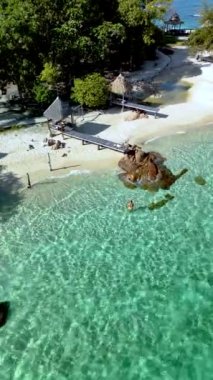 Koh Munnork Adası 'nın sakin kıyılarını keşfedin. Turkuaz suların kumlu kumsallara ve yemyeşil alanlara dolaştığı huzurlu bir dinlenme yeri. Bir erkek ve bir kadın okyanusta dinleniyor.