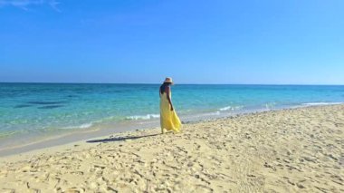 Tayland 'daki temiz kumsalları ve berrak mavi sularıyla Koh Munnork Adası. Rahatla, gevşe ve seni bekleyen tropik cenneti kucakla. Sahilde elbise giymiş Asyalı kadınlar.