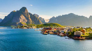 Norveç 'teki Reine köyünü keşfedin. Lofoten Adaları' nda görkemli dağlar ve sakin sular gün batımında maceracılar ve doğa severler için ideal bir zemin oluşturur.