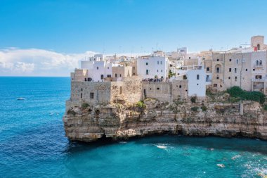 Polignano a Mare Vibrant beyaz binalar engebeli uçurumlara tutunur, sakin turkuaz sulara bakar. Ziyaretçiler İtalya 'nın güzel Puglia kentindeki çarpıcı kıyı manzarasının tadını çıkarıyorlar.