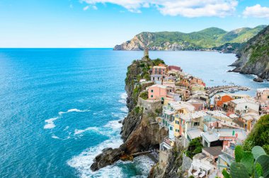 Parlak bir gökyüzü altında dalgalı tepeler ve canlı kıyı yaşamlarıyla çevrili açık deniz kıyısındaki uçurumlara yapışmış canlı binaların bulunduğu nefes kesici Cinque Terre 'yi keşfedin. Vernazza İtalya Yazın