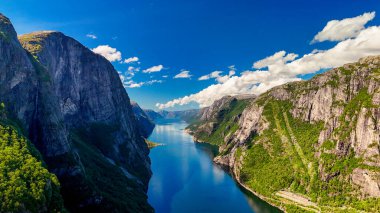 Norveç fiyordunun nefes kesen manzarası, yükselen uçurumlar, yemyeşil alanlar ve fiyordun kristal berrak suları. Yazın Kjerag, Lysebotn, Lysefjorden, Norveç