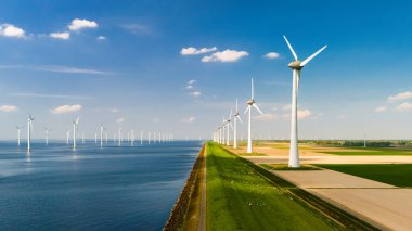 Yeşil enerji geçişi, yeşil alanlı yel değirmeni türbinleri, Hollanda 'da mavi gökyüzü yeşil enerji kavramına sahip elektrik üreten yel değirmeni türbinleri.