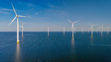 Yel değirmeni türbinleri, Hollanda 'da mavi gökyüzü yeşil enerji kavramına sahip elektrik enerjisi üretiyor. Okyanustaki deniz yel değirmeni çiftliği.