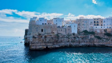 Ziyaretçiler Puglia 'nın soluk soluğa kalan uçurumlarına hayret ederken, kayalık kıyılara yapışan beyaz boyanmış binalar, antik kayalara yumuşak dalgalar çarpıyor, Polignano a Mare İtalya yazın