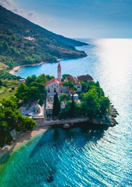 Brac Adası 'nın çarpıcı kıyıları boyunca uzanan Hırvatistan, güneşin altında parıldayan pitoresk bir köy.