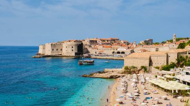 Dubrovnik Hırvatistan kıyı şeridi sıcak güneşin tadını çıkarırken, tarihi eski kasaba berrak mavi gökyüzü altında pırıl pırıl parlıyor ve zengin bir miras ve çarpıcı bir mimari sergiliyor..