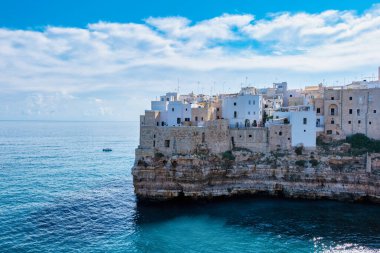 Polignano a Mare Waves nazikçe Puglia 'nın engebeli kayalıklarına çarpar ve yazın İtalya' nın sakin Akdeniz sularına tepeden bakan beyaz renkli binaları gözler önüne serer.