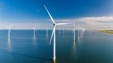 Yel değirmeni parkındaki İHA görüntüsü, Hollanda 'da mavi gökyüzü yeşil enerji kavramına sahip elektrik üreten yel değirmeni türbinleri.