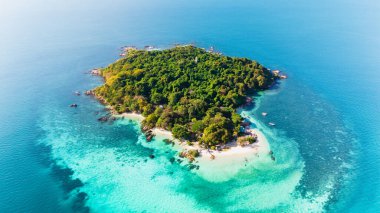 Bereketli yeşillik, Koh Munnork Adası Tayland 'ın çarpıcı sahillerine sınır komşusudur. Ziyaretçiler, parlak mavi gökyüzünün altında huzur ve doğal güzelliğin tadını çıkarırlar..