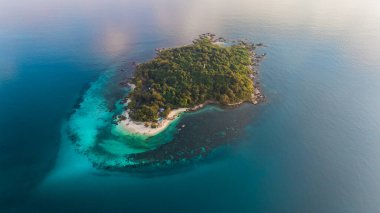 Tayland, Rayong 'daki Koh Munnork Adası' nda kristal berrak sular ve yemyeşil alanlar sergileniyor. Ziyaretçiler kumlu sahilde güneşlenebilir ve dinlenmek için mükemmel sakin ortamların tadını çıkarabilirler..