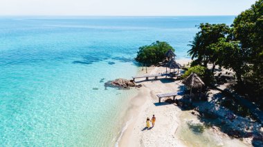 Yumuşak beyaz kumlar ve kristal berrak sular, Koh Munnork Adası Tayland 'ın sakin kıyıları boyunca sakin bir şekilde gezinen ziyaretçileri çevrelemektedir..