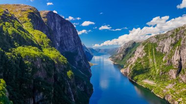 Norveç fiyordu, yükselen kayalıklar, yemyeşil yemyeşil ve fiyordun kristal berrak suları. Yazın Kjerag, Lysebotn, Lysefjorden, Norveç