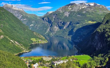 Bereketli yeşil tepeler ve parlak mavi gökyüzünün altında yükselen karlı dağlarla çevrili sakin bir fiyordun nefes kesici manzarası. Yazın Norveç 'e Geiranger