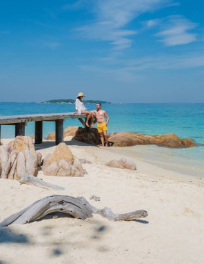 Koh Munnork Adası Tayland 'da dinlenen iki arkadaş, sıcak güneş ışığı altında güzel plajın tadını çıkarıyorlar. Kristal berrak sular ve nazik dalgalar mükemmel bir tropikal kaçış yaratır..