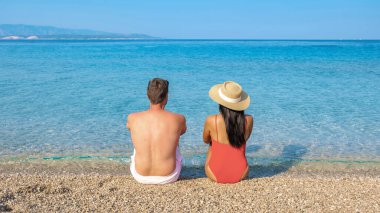 Hırvatistan 'ın Brac Adası' nın berrak sularında, ılık yaz güneşinin tadını çıkaran bir çift, huzurlu bir anın tadını çıkarıyor. Zlatni Rat Sahili çakıl taşları yazın dinlenmek için mükemmel bir yer.