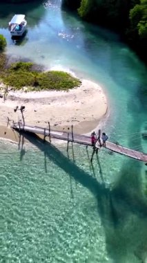 Koh Kood Adası 'nın nefes kesici manzaralarını keşfedin. Ziyaretçiler, berrak sular ve yemyeşil Tayland' ın doğal sakinliği ile çevrili kırsal ahşap bir köprü boyunca yürürken.