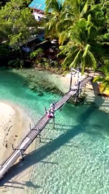 Koh Kood Adası 'nın büyüleyici atmosferini keşfedin. Sakin, ahşap bir köprü, çarpıcı turkuaz suların üzerinde uzanıyor. Bereketli palmiye ağaçları ve canlı doğa Tayland 'da mükemmel bir cennet yaratır.