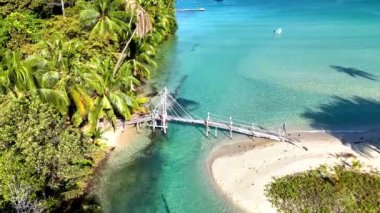 Tayland 'daki Koh Kood Adası' nın sakin güzelliği. Turkuaz suların çarpıcı kumlu kıyılarla buluştuğu yer. Yeşillik ve ahşap köprünün etrafındaki sakin dalgalarla çevrili huzurlu bir kaçış deneyimi.