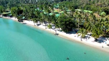 Tayland 'daki Koh Kood Adası' nın sakin plajlarını ve kristal berrak sularını deneyin. Tomurcuklanan palmiye ağaçları, ziyaretçiler gibi yavaşça sallanıyor. Bu saklı mücevherde güneşin ve denizin tadını çıkarıyorlar..